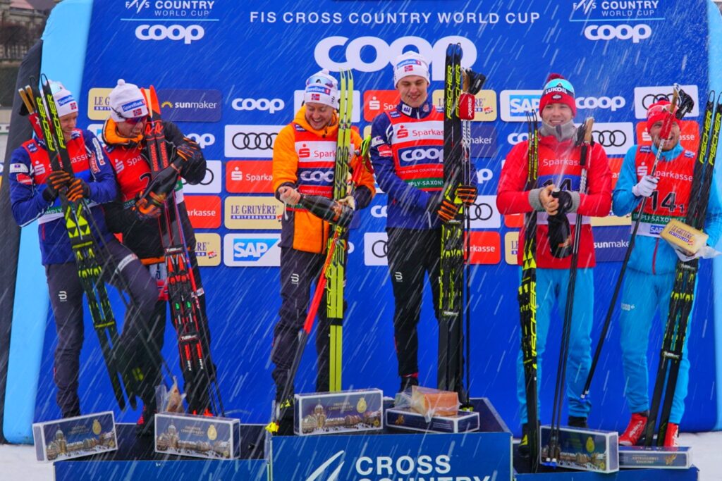 Men’s team sprint podium celebrates with champagne.