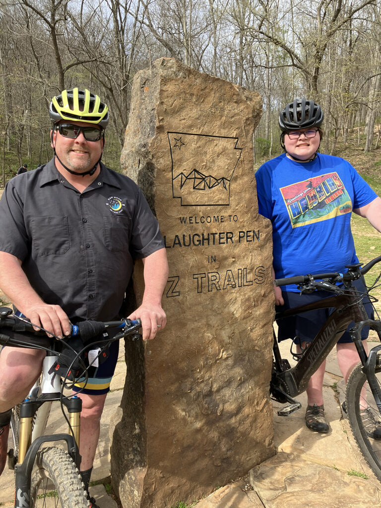 New Moon owner Chris Young and his son take a break at Slaughter Pen trail in Bentonville