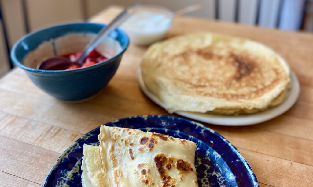 Enjoying homemade Pönnukökur with strawberries and whipped cream